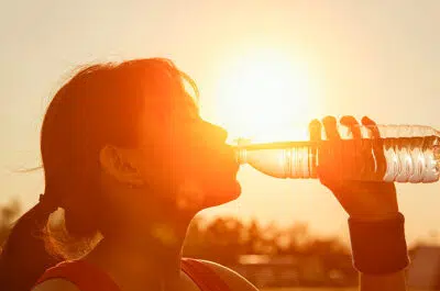 Sportif buvant de l'eau en plein soleil – coup de chaleur et exercice sportif | IK