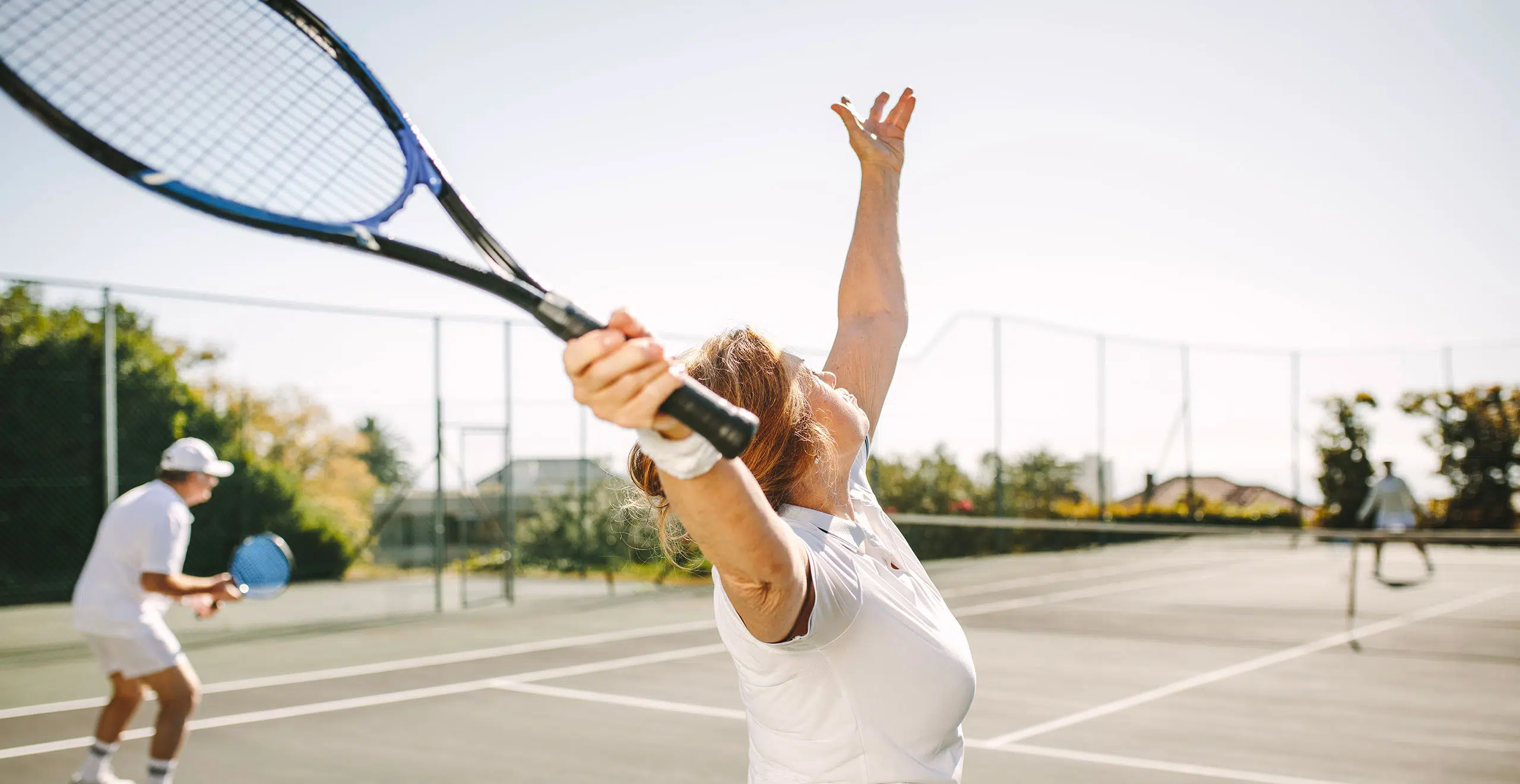 Femme agee jouant au tennis avec un homme agee - pathologie coiffe rotateurs epaule | IK Paris