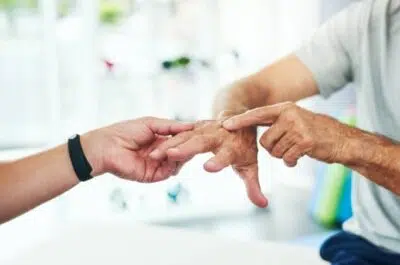 Mains d'une personne âgée tenues par un kiné – arthrose de la main | IK Kiné et Balnéo Paris