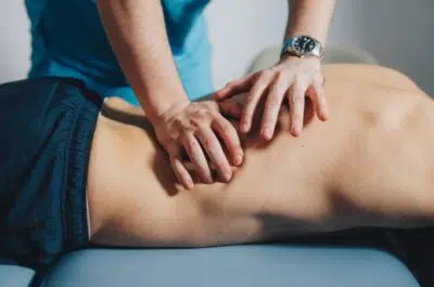 Mains d'un kiné massant le dos d'un patient – kiné en urgence, les bons réflexes | IK