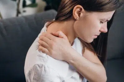 Jeune femme se tenant la nuque – la cervicalgie, un problème à ne pas négliger | IK