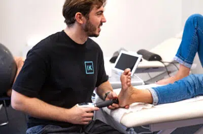 Kiné examinant un patient avec une tablette – ChatGPT ne peut pas évaluer la douleur | IK
